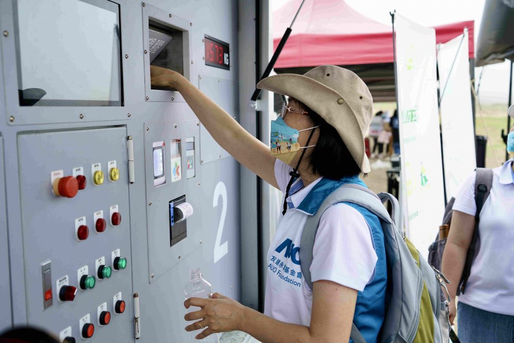 志工們將拾起的寶特瓶投入「好歸塑專車」，讓廢棄塑料空瓶可以直接粉碎、縮小體積，未來將可再製成購物袋、寶特衣、悠遊卡等生活用品